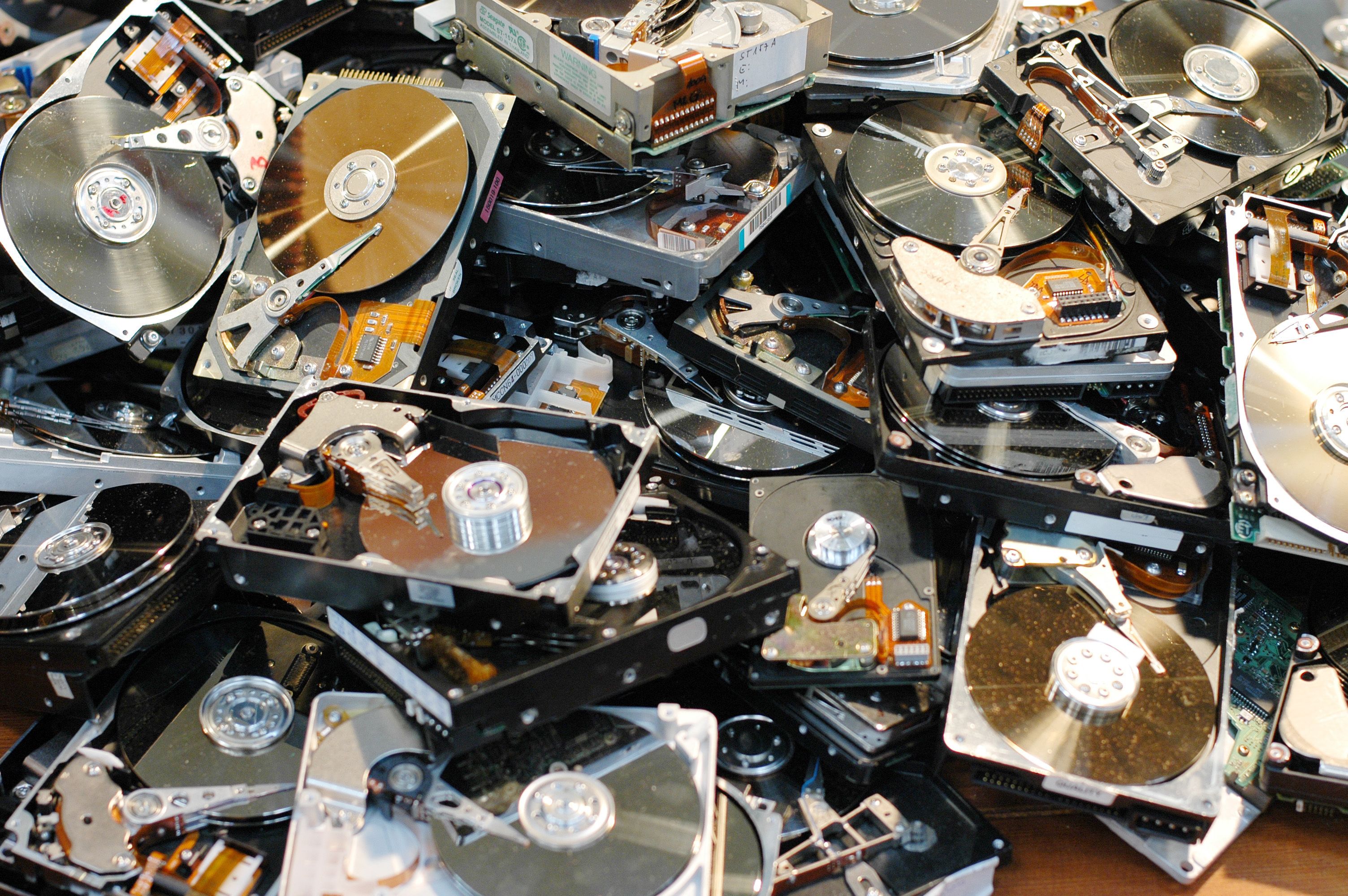 Много использованных дисков. Компьютерный диск. Много жестких дисков. Жесткие диски куча. Свалка жестких дисков.