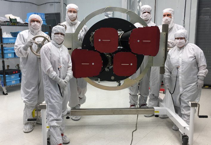 Инженеры позируют на фоне четырех камер, установленных на зонде TESS. Фото: NASA