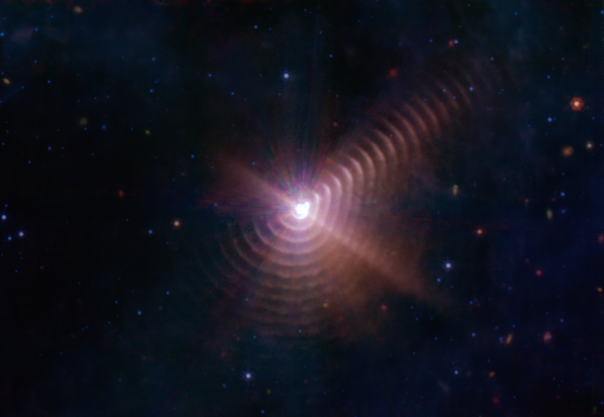 Візерунок, схожий на відбиток пальця, на цьому зображенні Вебба створений із пилового сміття, яке періодично відкидає одна із зірок Вольфа-Райє 140. Зображення: NASA, ESA, CSA, STScI, JPL-Caltech, CC BY 2.0