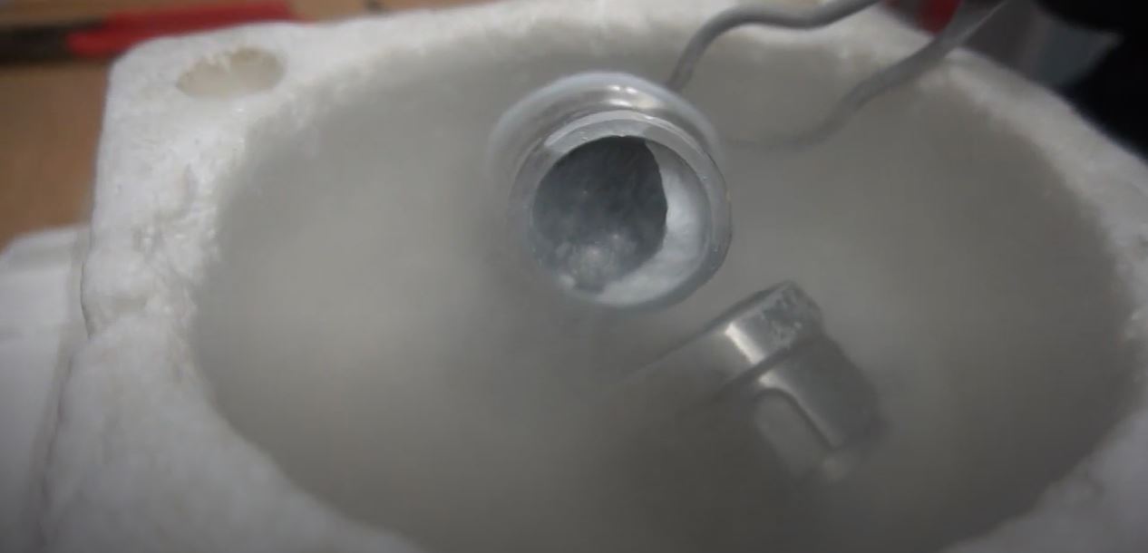 Скриншот із відео дослідників, на якому показано банку з аморфним льодом середньої щільності, сталевими кульками та рідким азотом.