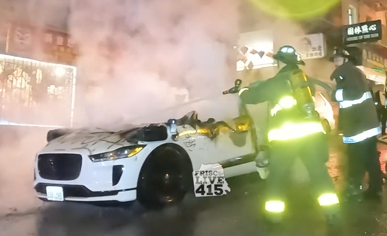A crowd smashed and set fire to a self-driving Waymo taxi in San Francisco.  There was no one in the car