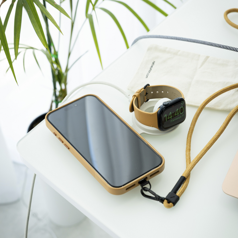 Бездротова зарядка Native Union Voyage 2-in-1 Qi2 зі смартфоном iPhone та годинником Apple Watch на білому столі.