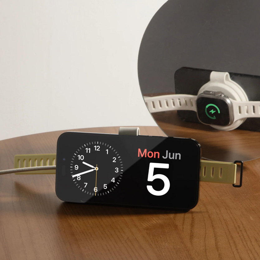 iPhone у режимі StandBy на зарядній станції Native Union Voyage 2-in-1 Qi2 поряд із Apple Watch на фоні дзеркала.
