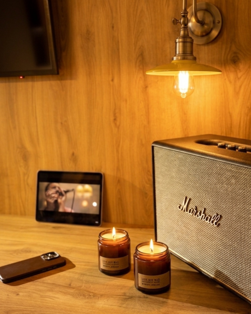 Акустична система Marshall Woburn III у затишній вечірній атмосфері при свічках, ідеальна для тихого прослуховування музики та релаксації.