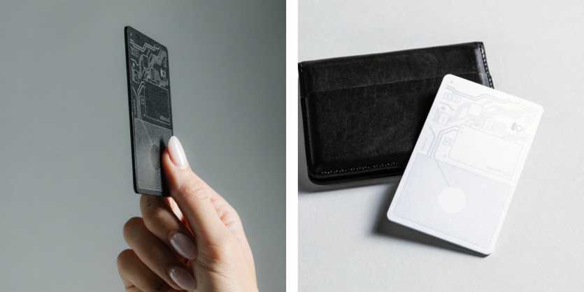 Розумна карта-трекер Nomad Tracking Card у чорному та білому кольорах поруч із гаманцем для відстеження через Find My.
