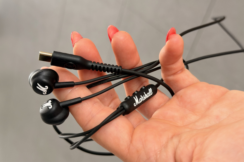 Жіноча рука з червоним манікюром тримає дротові навушники Marshall Mode USB-C.