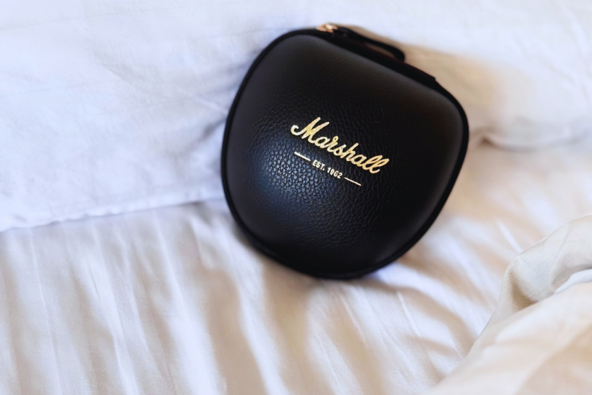 Преміальний чорний шкіряний кейс для навушників Marshall Monitor III лежить на білій постільній білизні.