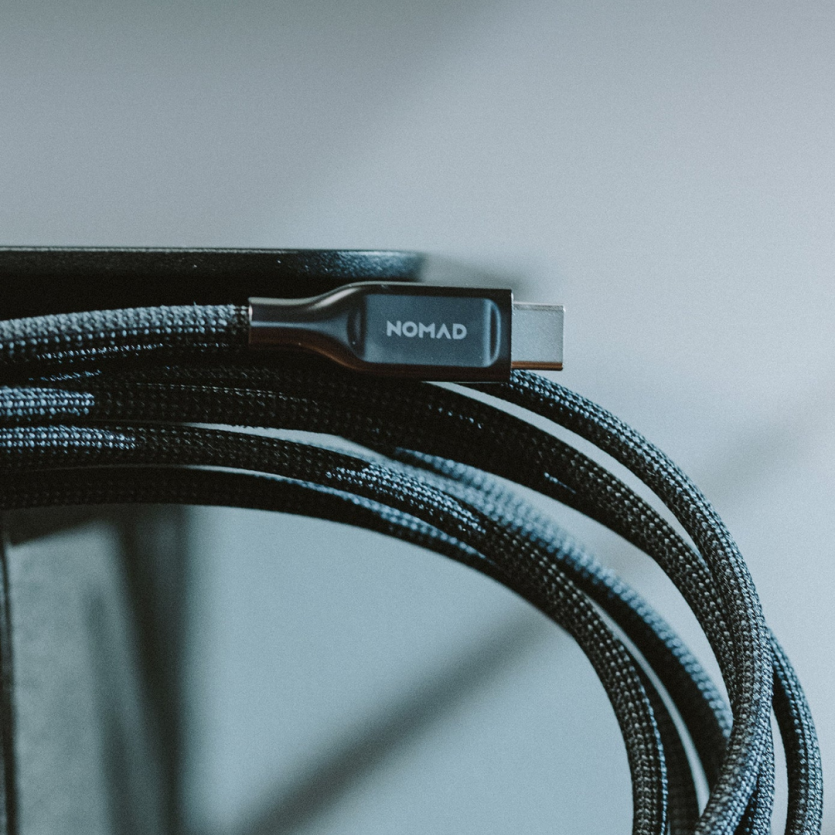 Кабель Nomad USB-C з посиленим нейлоновим обплетенням на фоні мінімалістичного сучасного робочого простору.