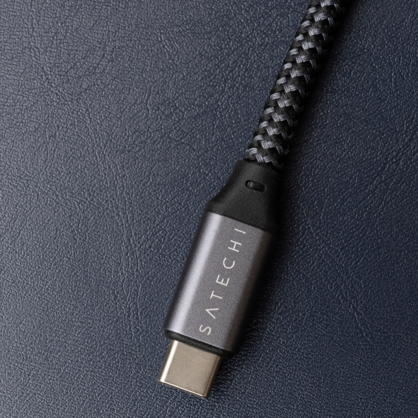 Надійний кабель Satechi USB-C у темно-сірому нейлоновому обплетенні на фоні преміальної шкіряної поверхні.